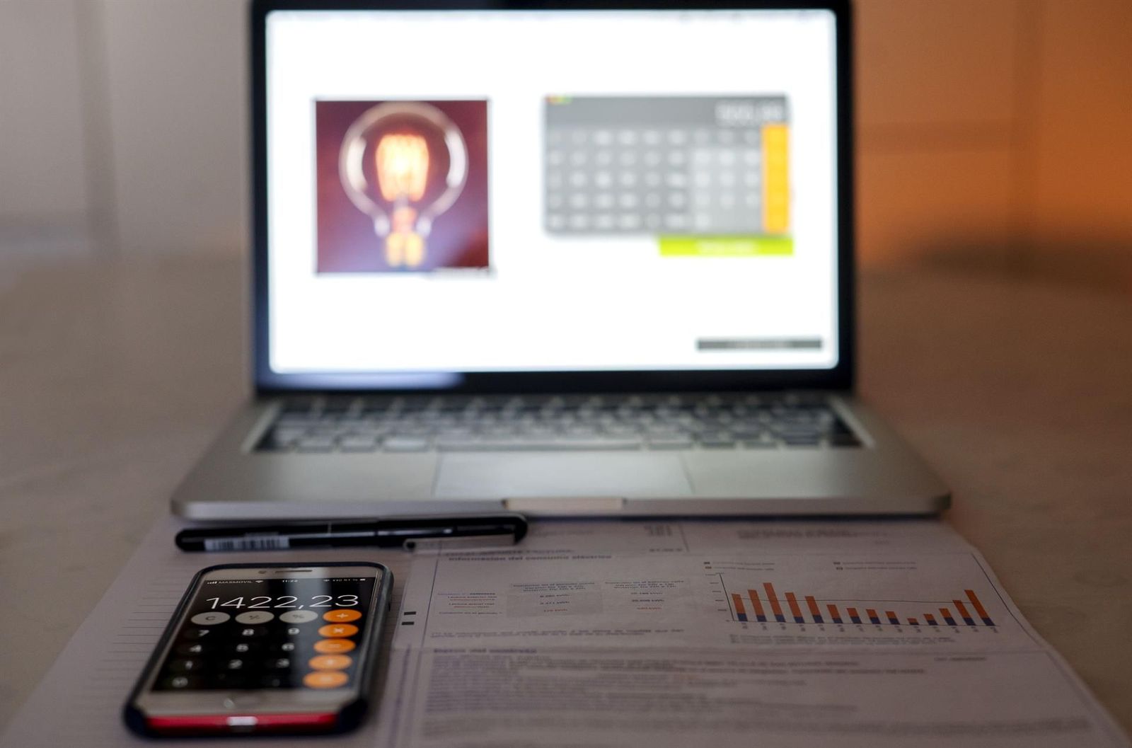 Un ordenador portátil, una calculadora y una factura de la luz. EP